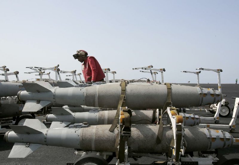 A U.S. Navy sailor readies bombs for loading onto jets last week on the deck of the USS Carl Vinson aircraft carrier in the Persian Gulf. Saudi Arabia’s involvement in a conflict against Iranian-backed rebels in Yemen is raising concerns about the safety of the region’s oil-supply routes. 
