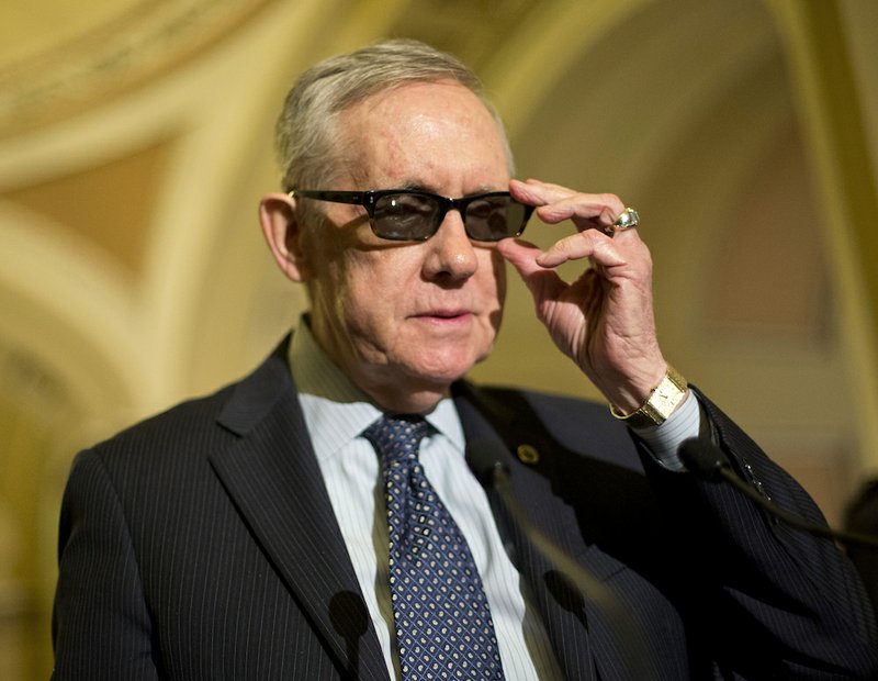 Senate Minority Leader Harry Reid of Nevada speaks to reporters on Capitol Hill in Washington on Tuesday, March 24, 2015, after a policy luncheon. Reid is wearing special glasses as part of his recovery from injuries suffered in an exercise accident in January. 