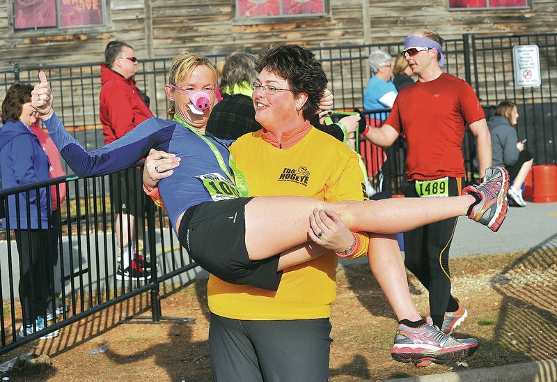 File Photo/Michael Woods&#8226; @NWAMICHAELW Pauline Allen from Fayetteville celebrates March 30 with her friend Jo Hudec after Allen took first place in the women&#8217;s division of last year&#8217;s Hogeye Half Marathon in Fayetteville.