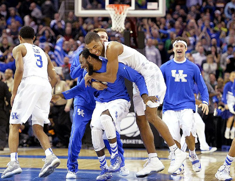 Kentucky players run to midcourt and celebrate after the Wildcats kept their hopes for an unbeaten season alive by beating Notre Dame 68-66 on Saturday night in the Midwest Region final in Cleveland. Andrew Harrison knocked down two free throws with six seconds remaining to help send Kentucky (38-0) to the Final Four for the fourth time in the past five years. 
