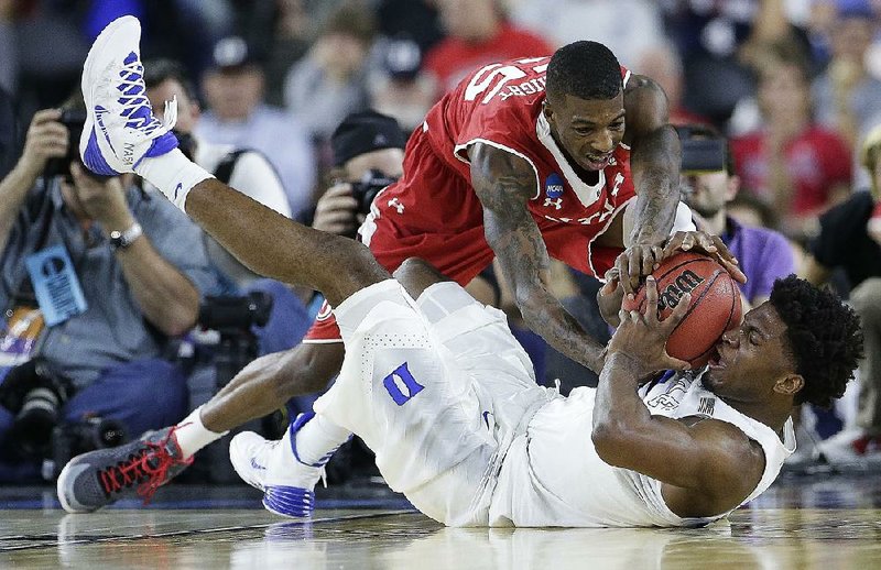 Duke’s Justise Winslow (bottom) and Utah’s Delon Wright battle for a loose ball during the first half of Friday’s game in the South Region semifinals at NRG Stadium in Houston. Winslow had 21 points and 10 rebounds to help Duke advance to the Elite Eight.