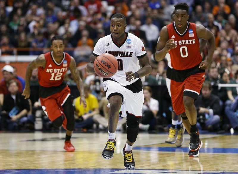 Louisville guard Terry Rozier (0) breaks away from North Carolina State’s Abdul-Malik Abu (right) during the first half of Friday’s 75-65 victory in the East Region semifinals at the Carrier Dome in Syracuse, N.Y. Rozier finished with 17 points and 14 rebounds.