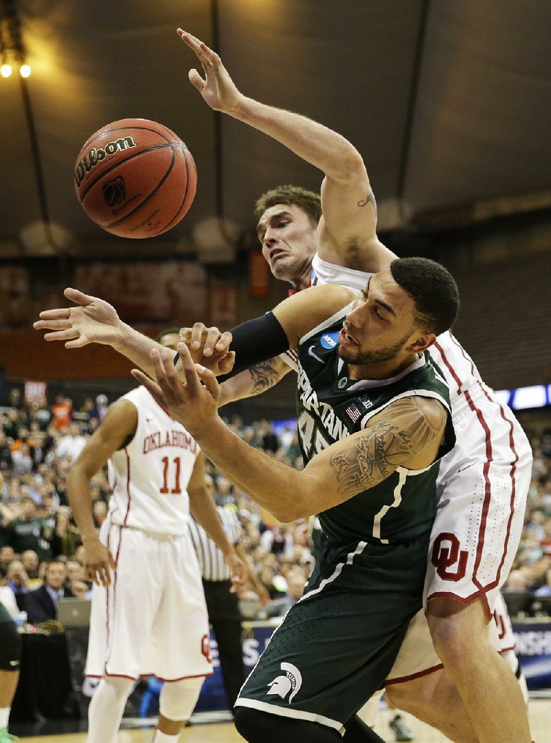 Michigan State’s Denzel Valentine (45) and Oklahoma’s Ryan Spangler (00) get tangled up during the second half of Friday’s game in the East Region semifinals at the Carrier Dome in Syracuse, N.Y. Valentine finished with 18 points to lead the Spartans.