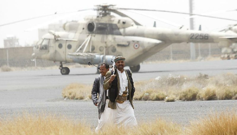 Shiite Houthi rebels stand guard Saturday on the tarmac at Sanaa International Airport in Yemen. Commercial flights to the country have been cut off. 