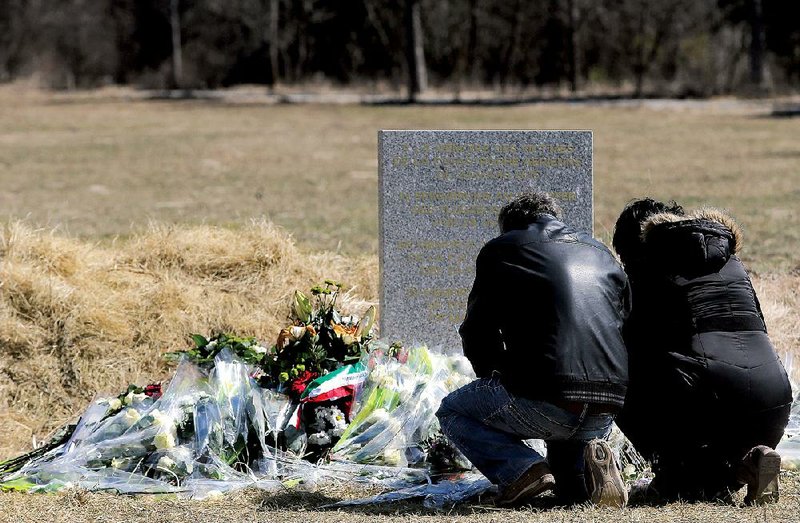 Grieving family members stop Friday at a plaque in Le Vernet, France, memorializing the victims of Germanwings Flight 9525.