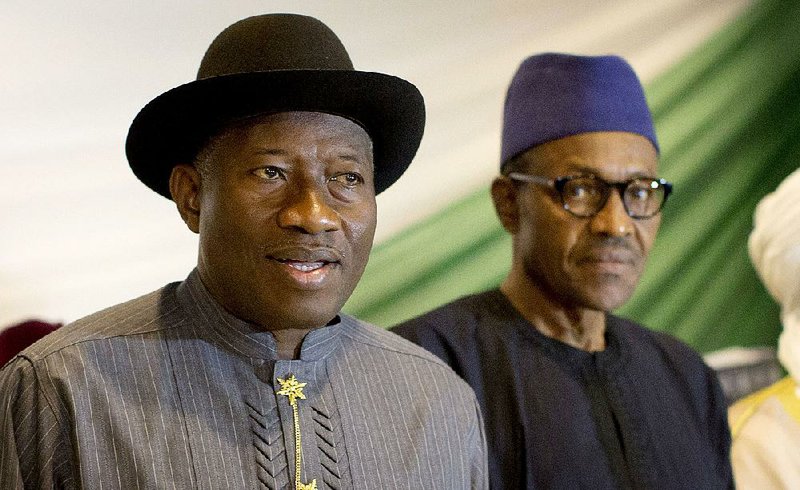 Nigeria's President Goodluck Jonathan, left, and opposition candidate Gen. Muhammadu Buhari, right, prepare to sign a renewal of their pledge to hold peaceful "free, fair, and credible" elections, at a hotel in the capital Abuja, Nigeria Thursday, March 26, 2015.