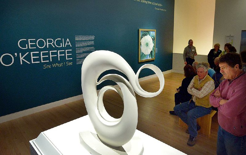 Visitors view Georgia O’Keeffe’s Abstraction, a white-lacquered bronze sculpture, at its unveiling Friday at Crystal Bridges Museum of American Art. In back is O’Keeffe’s Jimson Weed/White Flower No. 1. 