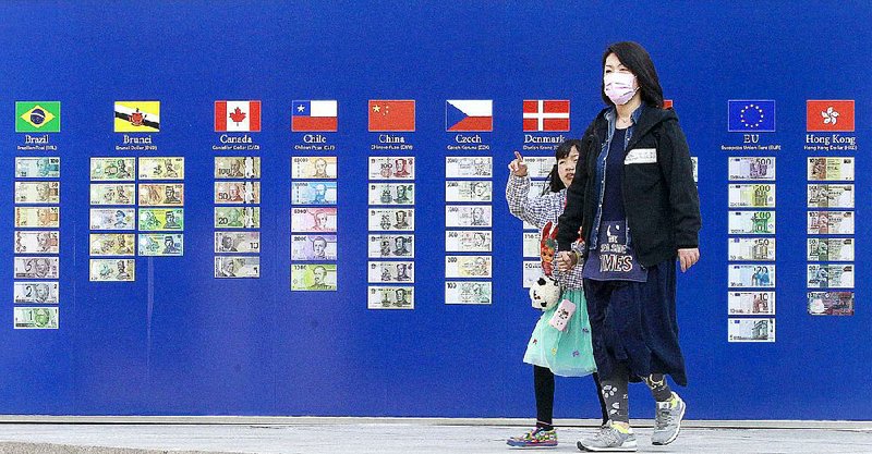Pedestrians pass a board Friday showing foreign currencies outside the Korea Exchange Bank in Seoul. South Korea announced Thursday that it will join the Asian Infrastructure Investment Bank. 