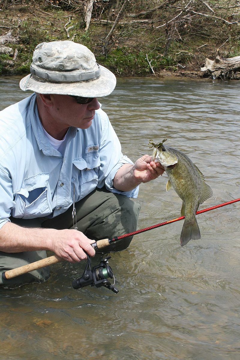 Rusty Pruitt admires his first smallmouth bass of the year, caught Wednesday in the South Fork of the Caddo River. 