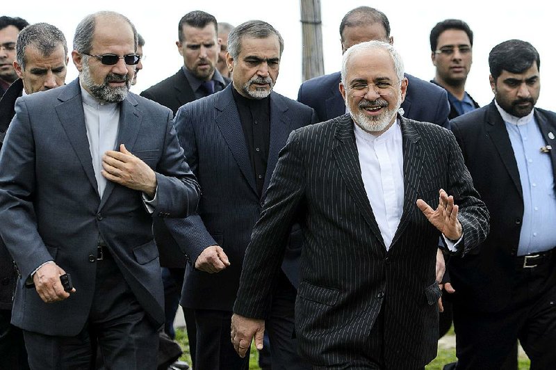 Iranian Foreign Minister Mohammad Javad Zarif (right) takes a break after meeting Friday with U.S. Secretary of State John Kerry in Lausanne, Switzerland. 