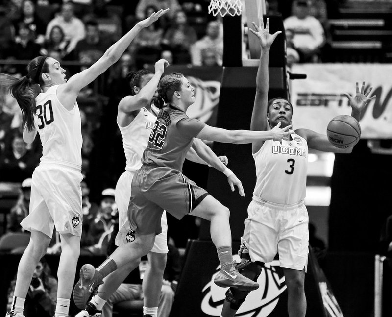 The Associated Press THREE'S A CROWD: Texas guard Brady Sanders (32) passes while surrounded by Connecticut's Breanna Stewart, left, Kiah Stokes and Morgan Tuck, right, during the first half of an NCAA women's regional semifinal on Saturday in Albany, N.Y. The top-seeded Huskies set a tournament margin-of-victory record, rolling 105-54.