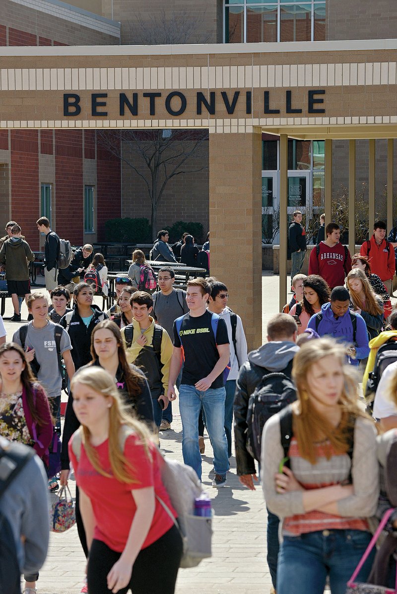 NWA Democrat-Gazette/BEN GOFF &#8212; Students pass between the north and south buildings of Bentonville High School during a class change March 12. Bentonville and Fayetteville students typically perform among the best on state math and literacy tests.