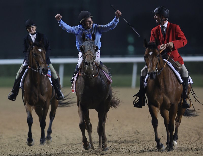  William Buick, middle, on UAE-owned Prince Bishop, celebrates after they won the $ 10,000,000 Dubai World Cup during the Dubai World Cup horse races at Meydan Racecourse in Dubai, United Arab Emirates, Saturday, March 28, 2015.
