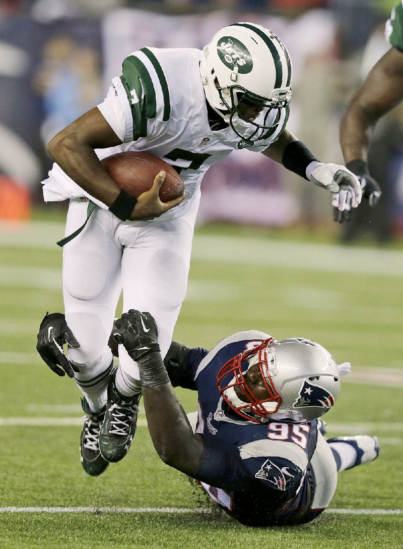 New England Patriots defensive end Chandler Jones, right, tackles New York Jets quarterback Geno Smith during the first half of an NFL football game Thursday, Oct. 16, 2014, in Foxborough, Mass. (AP Photo/Charles Krupa)