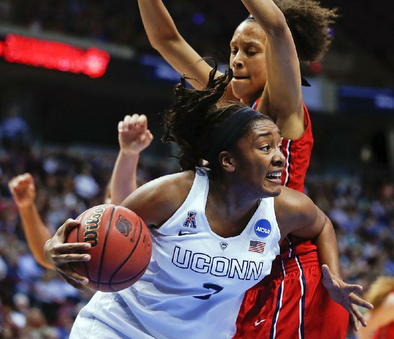 Connecticut forward Morgan Tuck, front, drives against Dayton center Jodie Cornelie-Sigmundova, of France during the first half of a regional final game in the NCAA women's college basketball tournament on Monday, March 30, 2015, in Albany, N.Y. (AP Photo/Mike Groll)