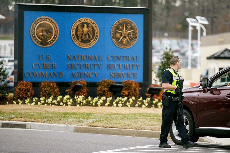 A police officer directs a vehicle to turn away at the National Security Agency, Monday, March 30, 2015, in Fort Meade, Md. Earlier, a firefight erupted when two men dressed as women tried to ram a car into a gate, killing one of them and wounding the other, officials said. (AP Photo/Andrew Harnik)