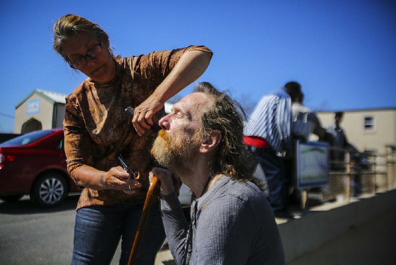 3/30/15
Arkansas Democrat-Gazette/STEPHEN B. THORNTON
Jericho Way client Genenda Gentry, left, trims the beard of fellow client Charles Shelly outside the  day resource center for the homeless in Little Rock Monday. Gentry says she often will trim hair free of charge for others at her shelter and Jericho Way.
