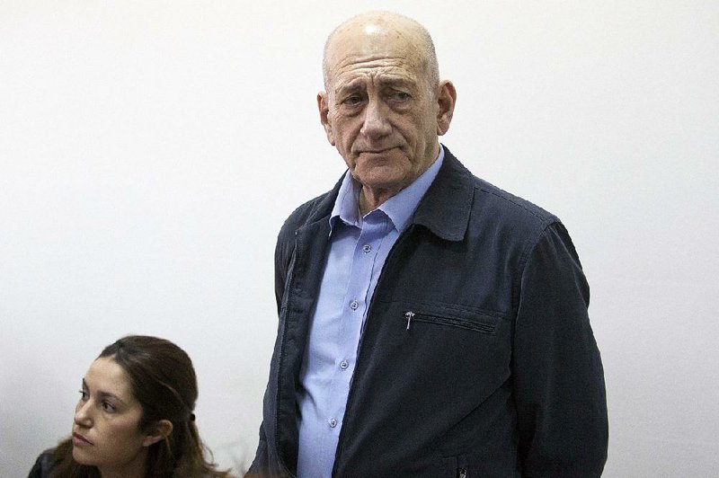 Former Israeli Prime Minister Ehud Olmert waits for a hearing in Jerusalem's District Court on Monday, March 30, 2015. The court later found Olmert guilty of accepting bribes in a retrial of corruption charges. (AP Photo/Abir Sultan, Pool)
