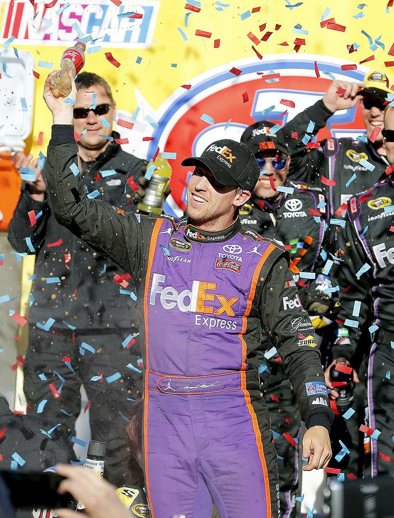 Denny Hamlin celebrates his win in the NASCAR Sprint Cup Series auto race at Martinsville Speedway in Martinsville, Va., Sunday, March 29, 2015. (AP Photo/Steve Helber)