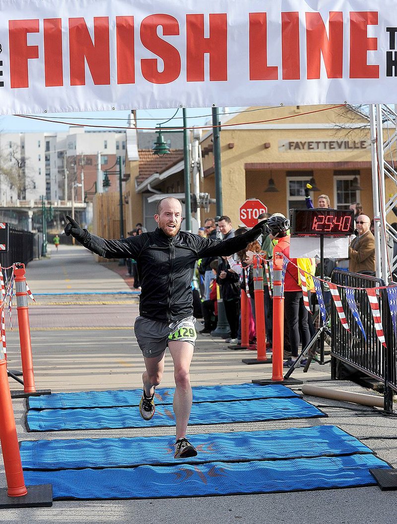 NWA Media/Michael Woods --03/30/2014-- w @NWAMICHAELW...Phil Davison from North Little Rock crosses the finish line to take first in the 38th Annual Hogeye Half Marathon Sunday morning in Fayetteville.  Davison finished with a time of 1:25:36.98