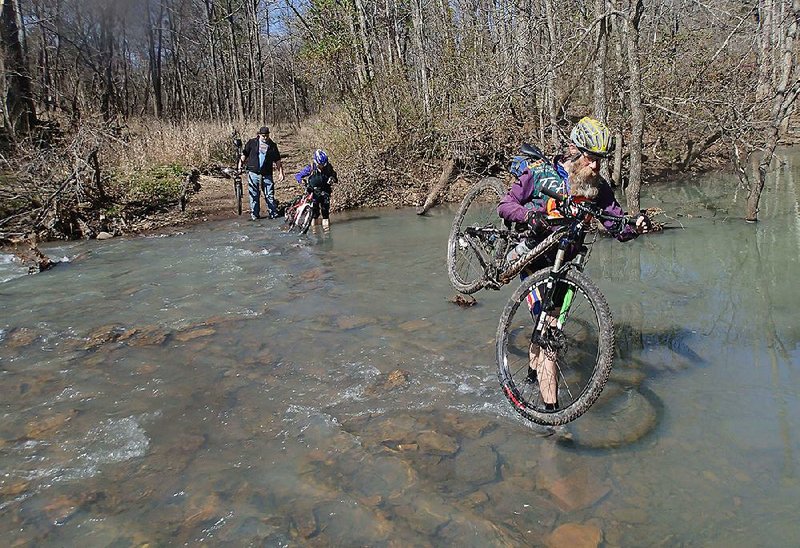 STAFF PHOTO FLIP PUTTHOFF 
Bob Cable, right, crosses Lee Creek while leading a guided ride at the Ozark Mountain Bike Festival. The 26th annual festival at Devil's Den State Park featured rides, trail seminars, a poker run and bicycling games for kids.