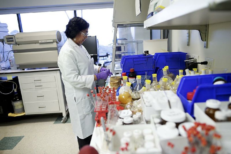 In this March 4, 2015 photo, Viji Arumugam, a scientist at Vertex Pharmaceuticals Inc. works in her laboratory in San Diego. The global pharmaceutical industry is pouring billions of dollars into developing treatments for rare diseases, which once drew little interest from major drugmakers but now point the way toward a new era of innovative therapies and big profits. Vertex hopes to have treatments for roughly 90 percent of cystic fibrosis patients by around 2020. (AP Photo/Gregory Bull)