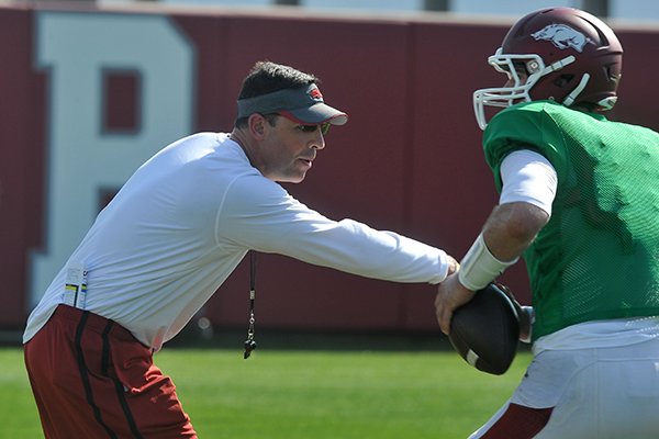 Arkansas offensive coordinator Dan Enos works with quarterback Brandon Allen during practice Tuesday, March 31, 2015, in Fayetteville. 