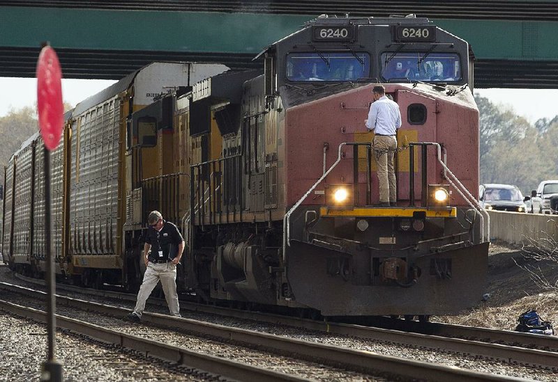 Little Rock police detectives investigate the death of an unidentified man Tuesday afternoon after he was struck by a train while walking along railroad tracks under Interstate 30 near South University Avenue. 