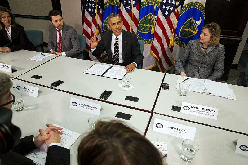 President Barack Obama, flanked by senior adviser Brian Deese (left) and Christina Goldfuss, managing director of the Council on Environmental Quality, speaks March 19 at the Energy Department in Washington.