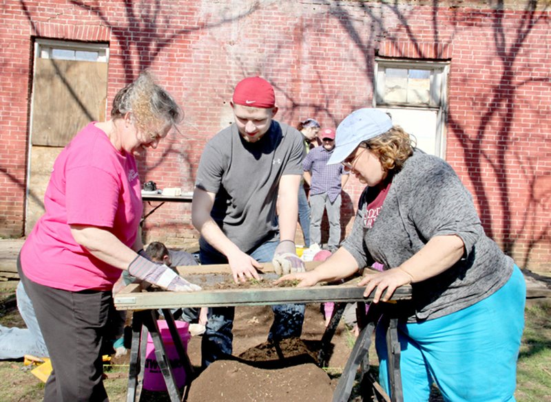 LYNN KUTTER ENTERPRISE-LEADER Starla Taylor of Fort Smith, left, Hagan Wiggins of Bentonville, and Kimberly Pyszka, an assistant professor of anthropology with Auburn University at Montgomery, Ala., sift through soil to look for artifacts from the former Methodist manse at Canehill.