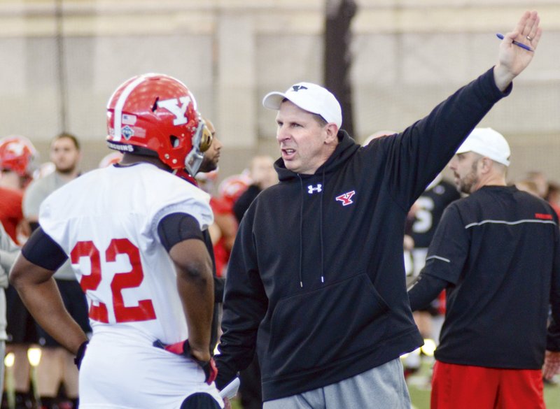 New Youngstown State Coach Bo Pelini give instructions to Dubem Nwadiogbu during spring practice two weeks ago. After being fired at Nebraska, Pelini has returned home to coach the Penguins.