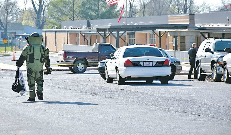 NWA Democrat-Gazette/TINA PARKER A member of Bentonville's Bomb Squad investigated a suspicious package Tuesday found outside of Northside Elementary School in Siloam Springs.