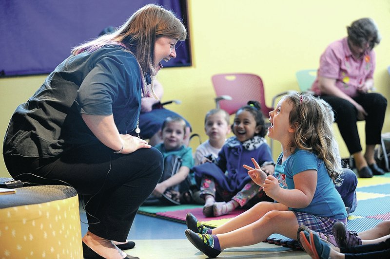 NWA Democrat-Gazette/ANDY SHUPE Alyson Low, (left) youth services librarian at the Fayetteville Public Library, laughs Tuesday with Harper Grace Henderson, 3, of Fayetteville as they both cluck like a chicken while singing a song during pre-school story time at the library. For photo galleries, go to nwadg.com/photos.