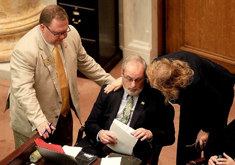 Rep. Kim Hammer (center) is congratulated Wednesday by Reps. Tim Lemon and Sheilla Lampkin after the bill to allow a monument to the Ten Commandments on the Capitol grounds won final approval in the House. 