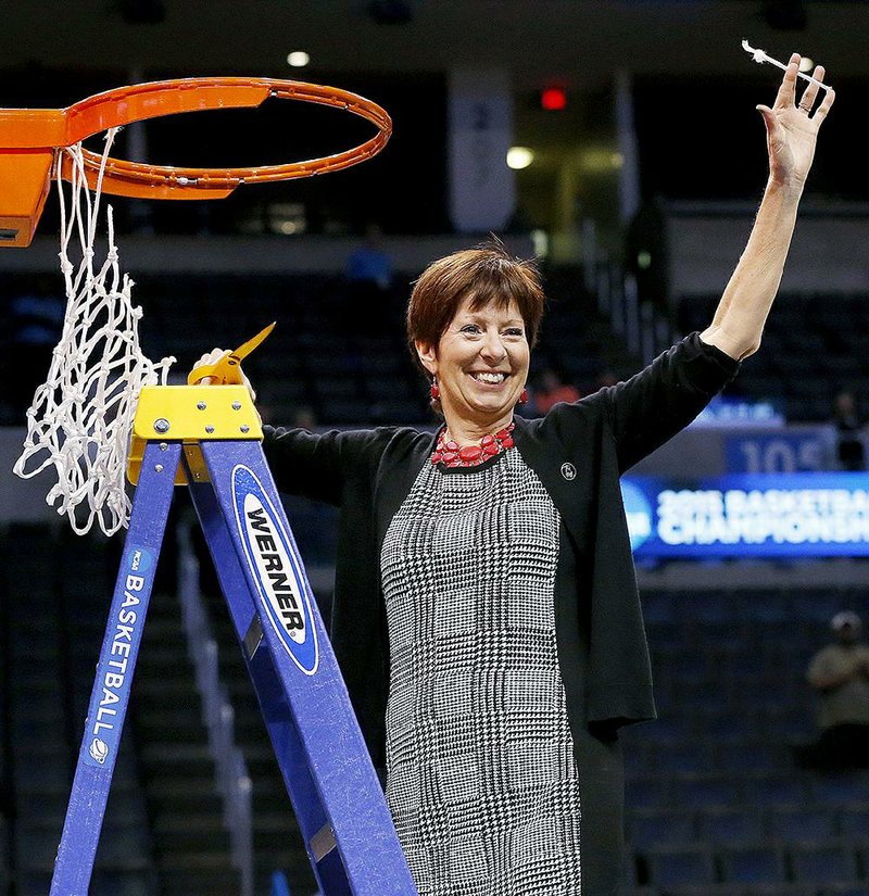 Notre Dame coach Muffet McGraw holds up part of the net after Notre Dame defeated Baylor 77-68 in a regional final in the NCAA women's college basketball tournament, Sunday, March 29, 2015, in Oklahoma City. 
