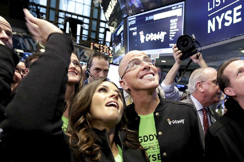 GoDaddy Inc. CEO Blake Irving and race-car driver Danica Patrick wave to a camera Wednesday on the floor of the New York Stock Exchange while waiting for GoDaddy shares to begin trading. 