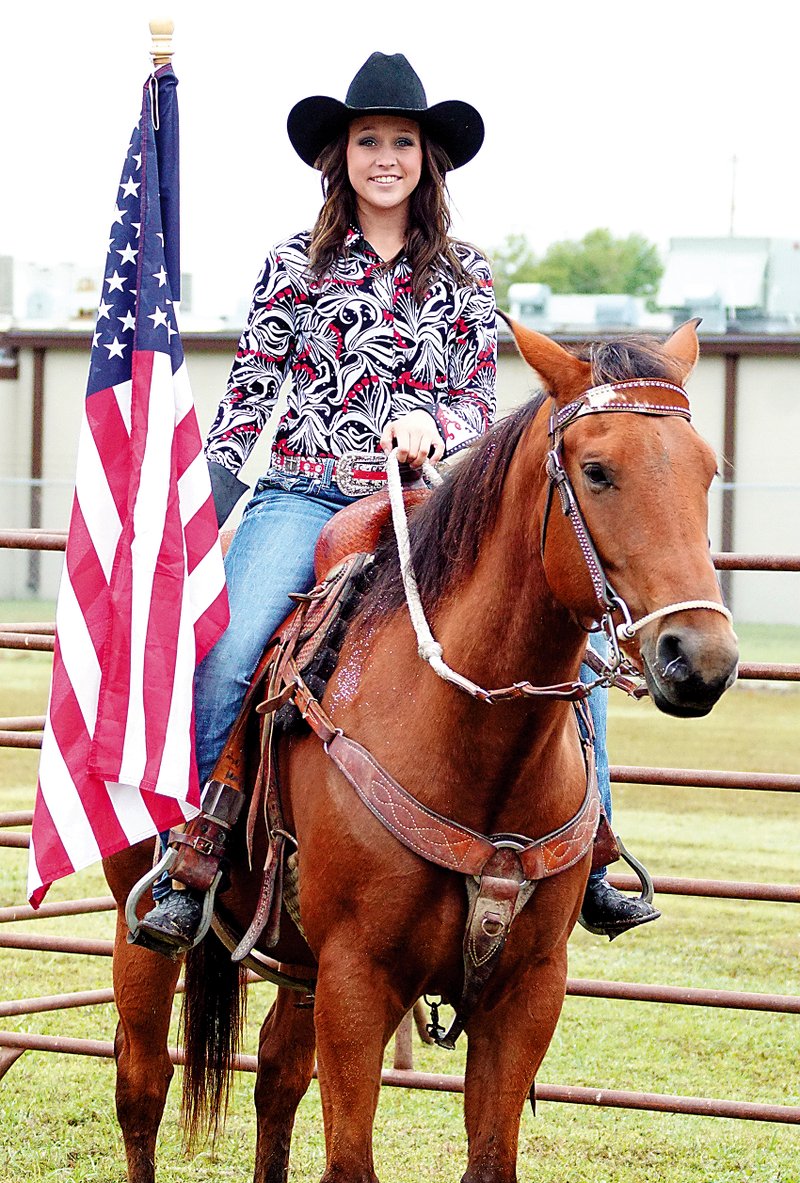 Karadie Ory carried the flag in the rodeo arena before the mutton bustin' competition at Gentry City Park during last year's fall festival in Gentry.