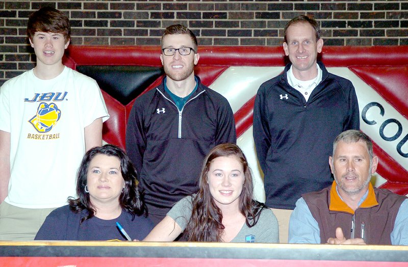 RICK PECK MCDONALD COUNTY PRESS McDonald County&#8217;s Preslea Reece (seated, center) recently signed a letter of intent to play basketball at John Brown University in Siloam Springs, Ark. Seated with Preslea are her parents, Angie and Shane Reece. Back row: Cooper Reece (brother), Blake Short, MCHS basketball coach, and Jeff Soderquist, head coach at John Brown University.