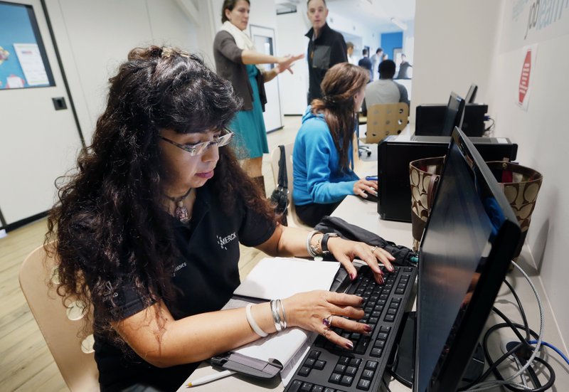In this Thursday, Oct. 16, 2014, file photo, Dorathy Vargas, foreground, uses a computer to search for a job at the office of CONNECT, a coalition of local organizations that provides employment services in Chelsea, Mass. Payroll processor ADP reports how many jobs private employers added in March on Wednesday, April 1, 2015.