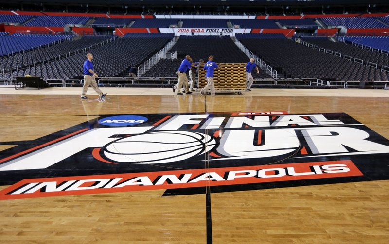 In this  file photo, workers at Lucas Oil Stadium install the court in Indianapolis as they prepare to host the men's NCAA Final Four college basketball games on April 4 and 6, 2015. NCAA officials say they are troubled by the new law in Indiana that critics fear could permit discrimination against gays and lesbians, and they "will assess all our championships in the state of Indiana," including next year's women's Final Four. Other sports organizations from the Indianapolis Motor Speedway, to the NBA's Pacers to the PGA have all scrambled to tell the public that they oppose discrimination.
