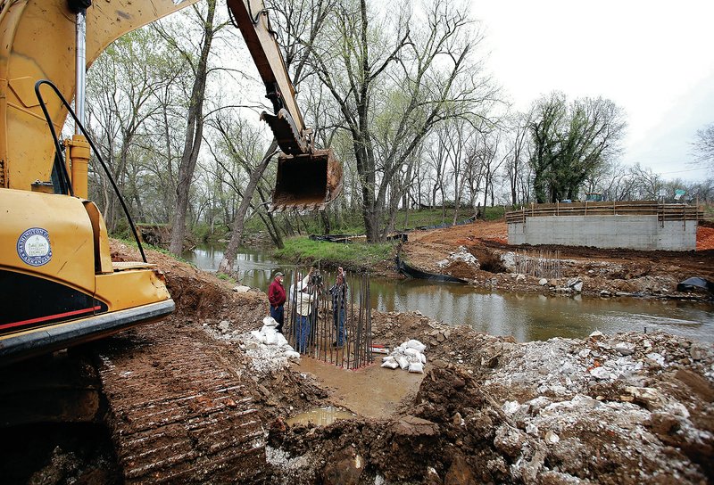 NWA Democrat-Gazette/DAVID GOTTSCHALK Washington County officials and personnel from GTS, an engineering firm of Fayetteville, do a hydraulic pressure test  on rebar attached to the footings of piers for the Stonewall Bridge on Stonewall Road in Washington County in an April file photo.