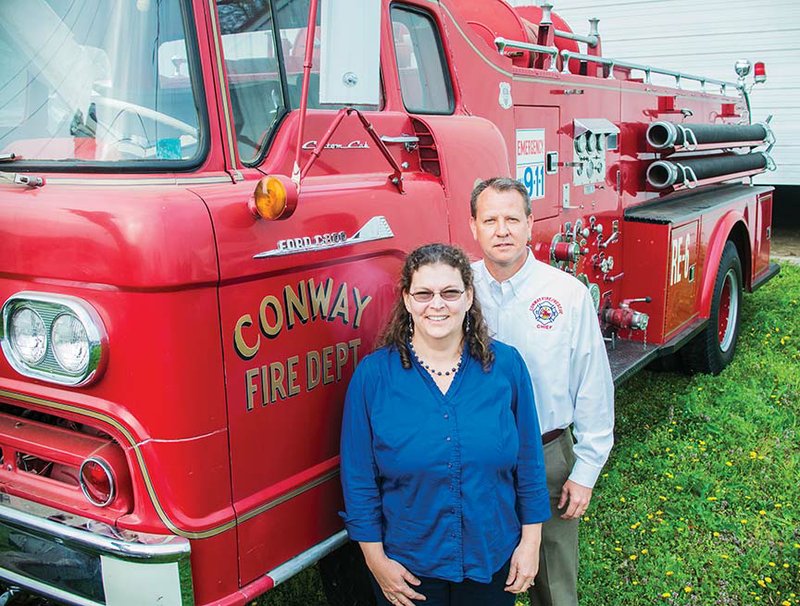 Lynita Langley-Ware, director of the Faulkner County Museum, and Conway Fire Chief Mark Winter stand with the 1960 firetruck that the museum is deeding back to the city. Langley-Ware said the museum took ownership of the truck in 2005, but it has been stored because there was no room to display it. Winter said the truck is important to the history of the city and will soon be stored in a bay at Station 4 on Salem Road.