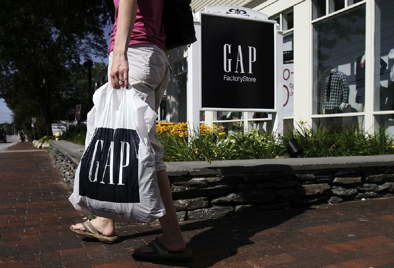 A shopper leaves the Gap store in Freeport, Maine. Gap raised wages for its workers over a year ago, beating retailers like Wal-Mart Stores Inc. and Target Corp. to the punch. 
