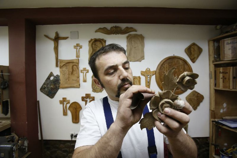 Edin Hajdarovac engraves decorations for a wooden chair for Pope Francis in his workshop in the Bosnian town of Zavidovici. Hajdarovac and his father, Salem, both devout Muslims, are building the chair for the pope’s visit in June. 
