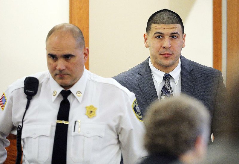 Former New England Patriots NFL football player Aaron Hernandez is led into the courtroom for his murder trial, Wednesday, April 1, 2015, at Bristol County Superior Court in Fall River, Mass. Hernandez is accused of killing Odin Lloyd in June 2013. (AP Photo/Brian Snyder, Pool)