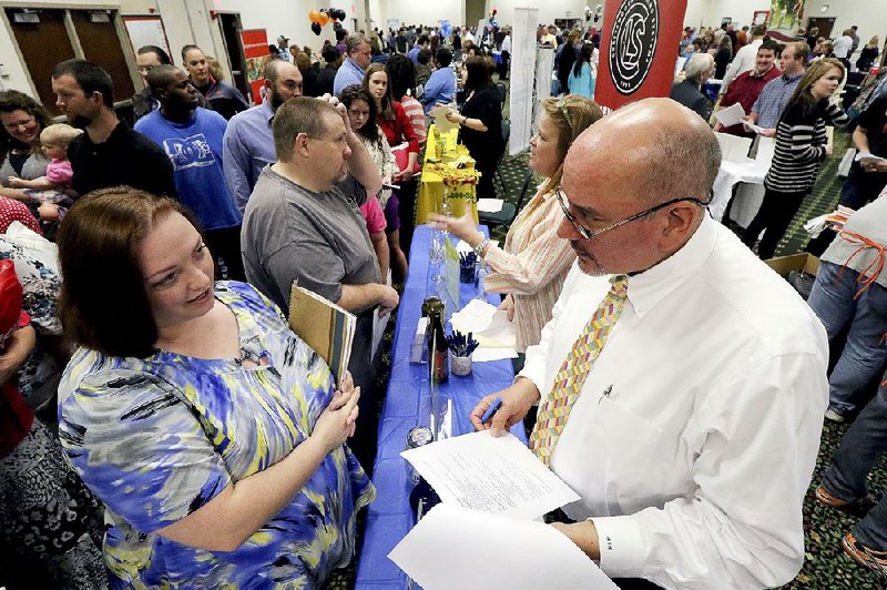 Frances Scoggins speaks to Michael McCall of Chattanooga Labeling Systems about her resume Thursday during a job fair in Ringgold, Ga. In the Labor Department’s numbers released Friday, the U.S. gained jobs, but not at the pace of previous months. 