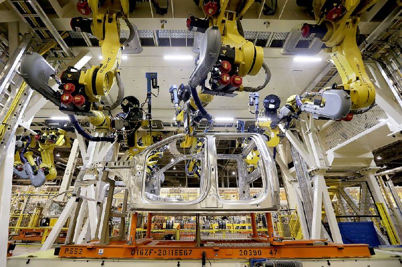 In this March 13, 2015 photo, robots fasten parts on a new 2015 aluminum-alloy body Ford F-150 truck in the body shop at the company's Kansas City Assembly Plant in Claycomo, Mo. The Commerce Department releases factory orders for February on Thursday, April 2, 2015. (AP Photo/Charlie Riedel)