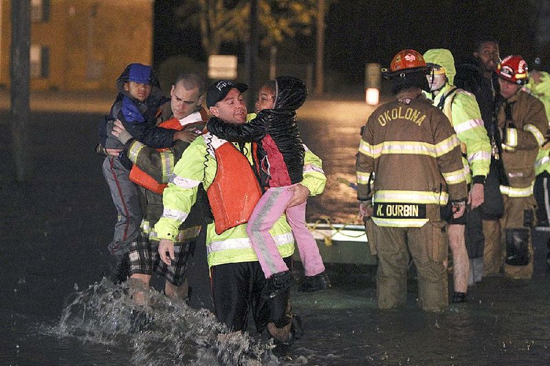 Rescue crews help evacuate an apartment complex after flooding Friday in Louisville, Ky. 