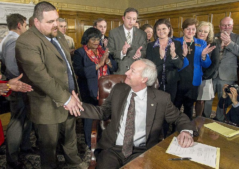 Arkansas Democrat-Gazette/BENJAMIN KRAIN --4/2/15--
Governor Asa Hutchinson congratulates Rep. Bob Ballinger, R-Hindsville, left, and other legislators after signing a controversial religious freedom bill SB 975 Thursday on the final day of the Legislative session.