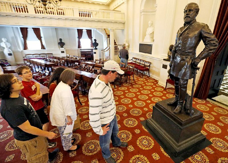 Rob Orrison (wearing cap) reads the inscription on the statue of Confederate Gen. Robert E. Lee during a tour Thursday of the Old House chambers at the Capitol in Richmond, Va.